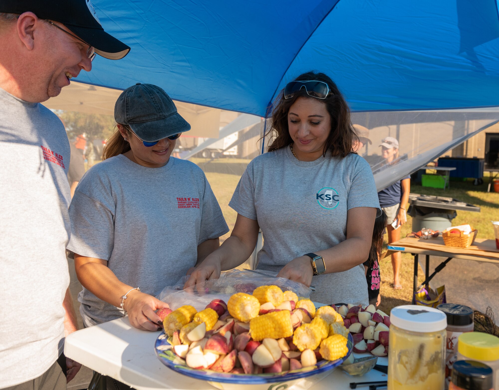 Members of the "Spicy Spouses" team prepare the 'fixins' during the Tails 'N Ales Annual Shrimp Cook-off outside the Bay Breeze Event Center at Keesler Air Force Base, Mississippi, Oct. 14, 2022. The 81st Force Support Squadron hosted event offered a variety of craft beers for tasting and many teams fighting for the ultimate best shrimp recipe. (U.S. Air Force photo by Andre' Askew)