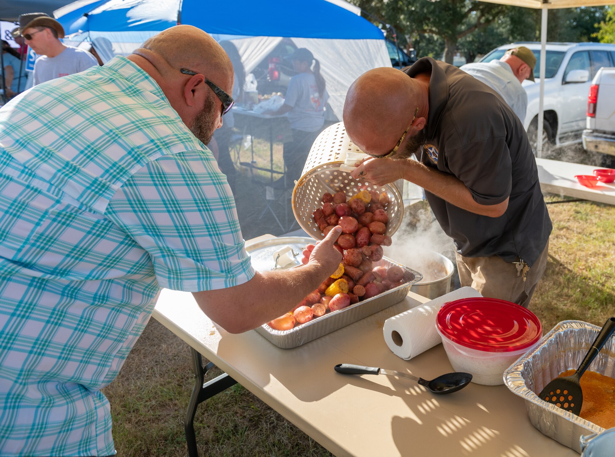 Members of the "Last Minute" team prepare the 'fixins' during the Tails 'N Ales Annual Shrimp Cook-off outside the Bay Breeze Event Center at Keesler Air Force Base, Mississippi, Oct. 14, 2022. The 81st Force Support Squadron hosted event offered a variety of craft beers for tasting and many teams fighting for the ultimate best shrimp recipe. (U.S. Air Force photo by Andre' Askew)