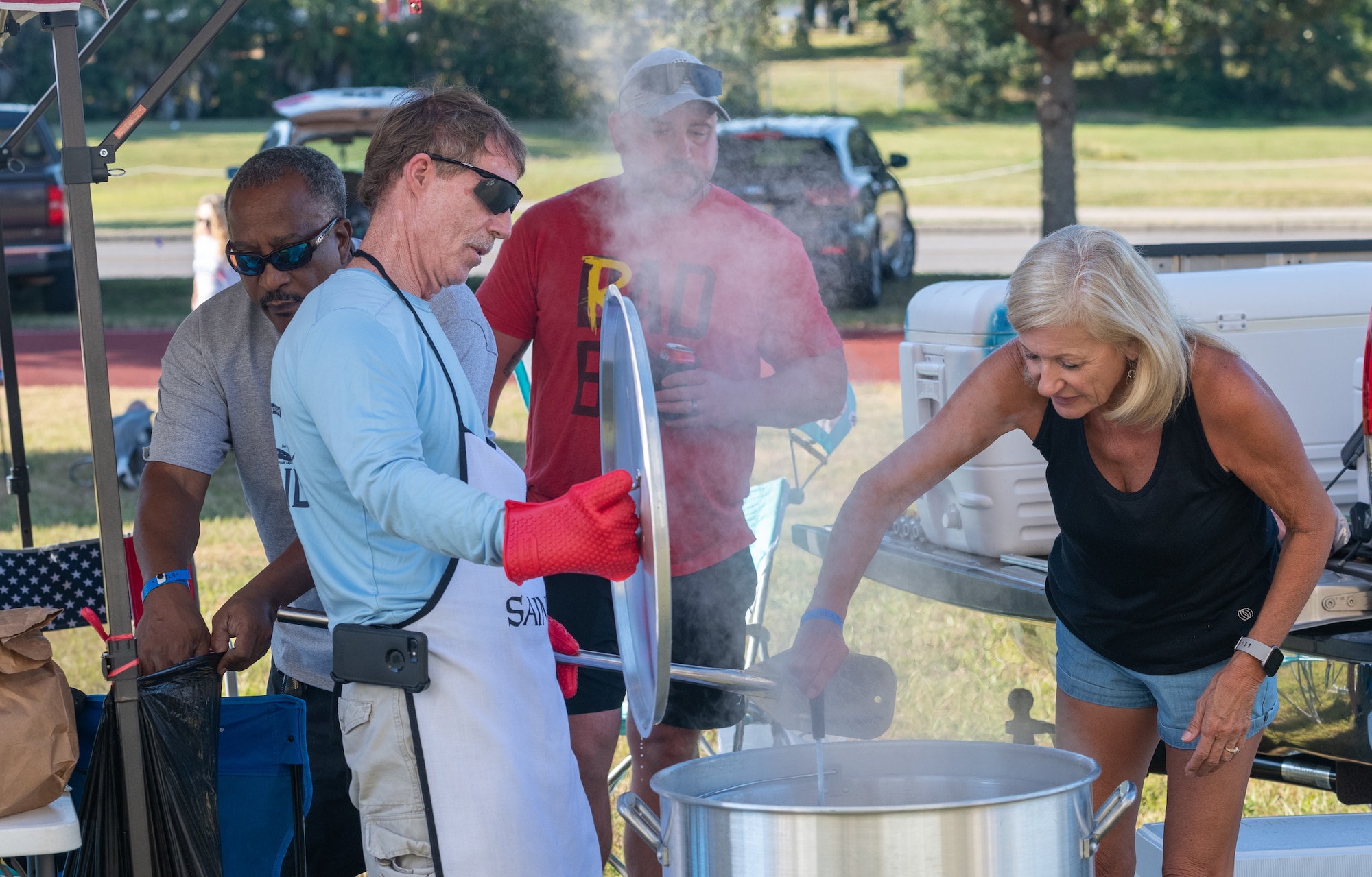 Members of the "Juicy Tales" team stir their pot of boiled shrimp during the Tails 'N Ales Annual Shrimp Cook-off outside the Bay Breeze Event Center at Keesler Air Force Base, Mississippi, Oct. 14, 2022. The 81st Force Support Squadron hosted event offered a variety of craft beers for tasting and many teams fighting for the ultimate best shrimp recipe. (U.S. Air Force photo by Andre' Askew)