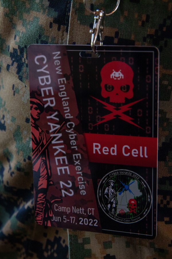 Red cell badges identify Marines during Cyber Yankee 22 on Camp Nett, Connecticut, June 14, 2022. During Cyber Yankee service members are divided up into red teams and blue teams. All participating Marines are part of the red team. The red team acts as an attacking force while the blue team tries to defend their network.