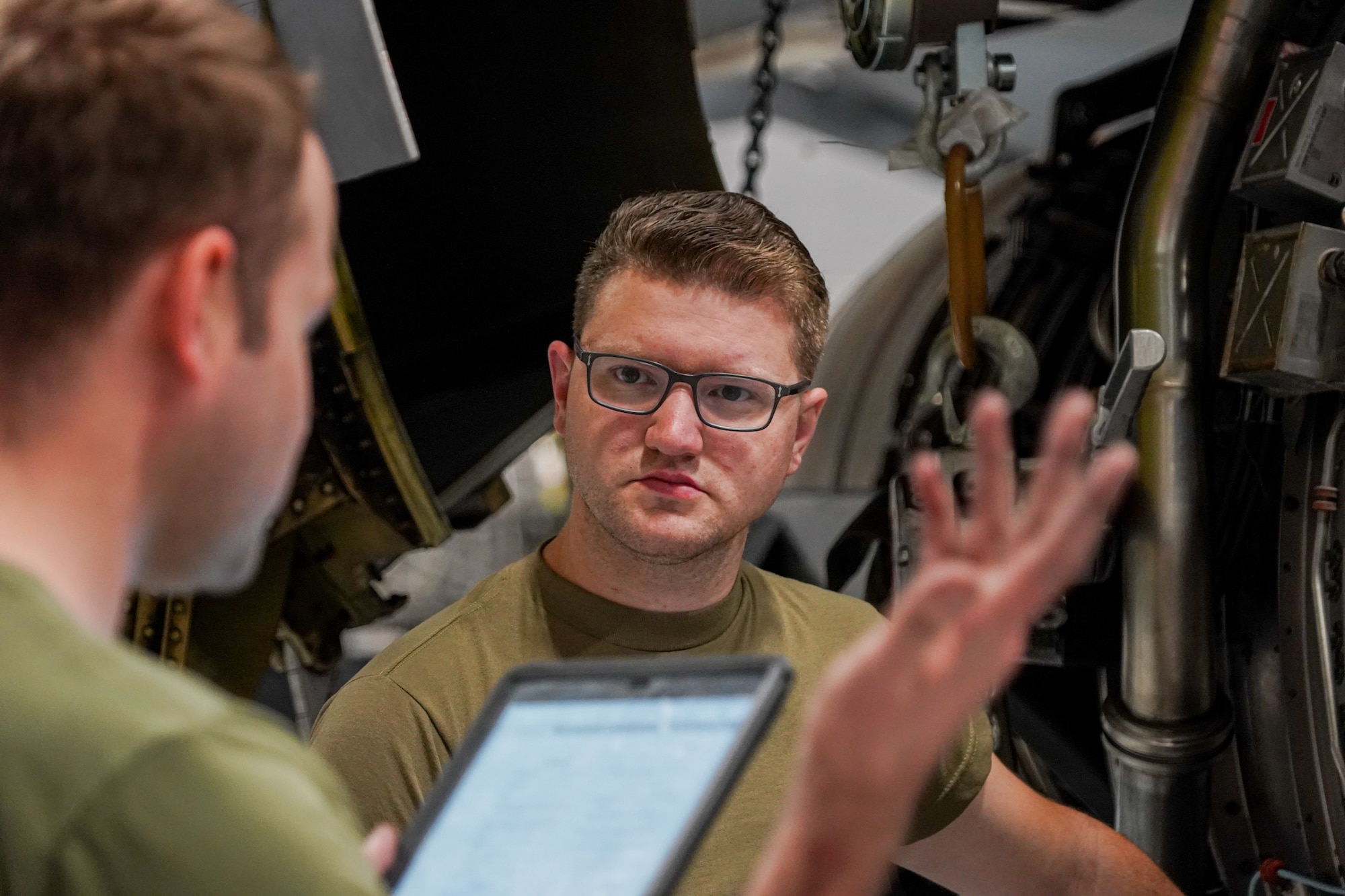 Staff Sgt. Casey Boots, an aerospace propulsion specialist from the 914th Aircraft Maintenance Squadron at Niagara Falls Air Reserve Station, New York, carefully listens to a briefing from Tech. Sgt. Alexander Brown, also an aerospace propulsion specialist from the same unit, before lifting a KC-135 Stratotanker engine into place on Oct. 18, 2022. The engine is undergoing careful maintenance following a bird strike. (U.S. Air Force photo by 1st Lt. Lucas Morrow)