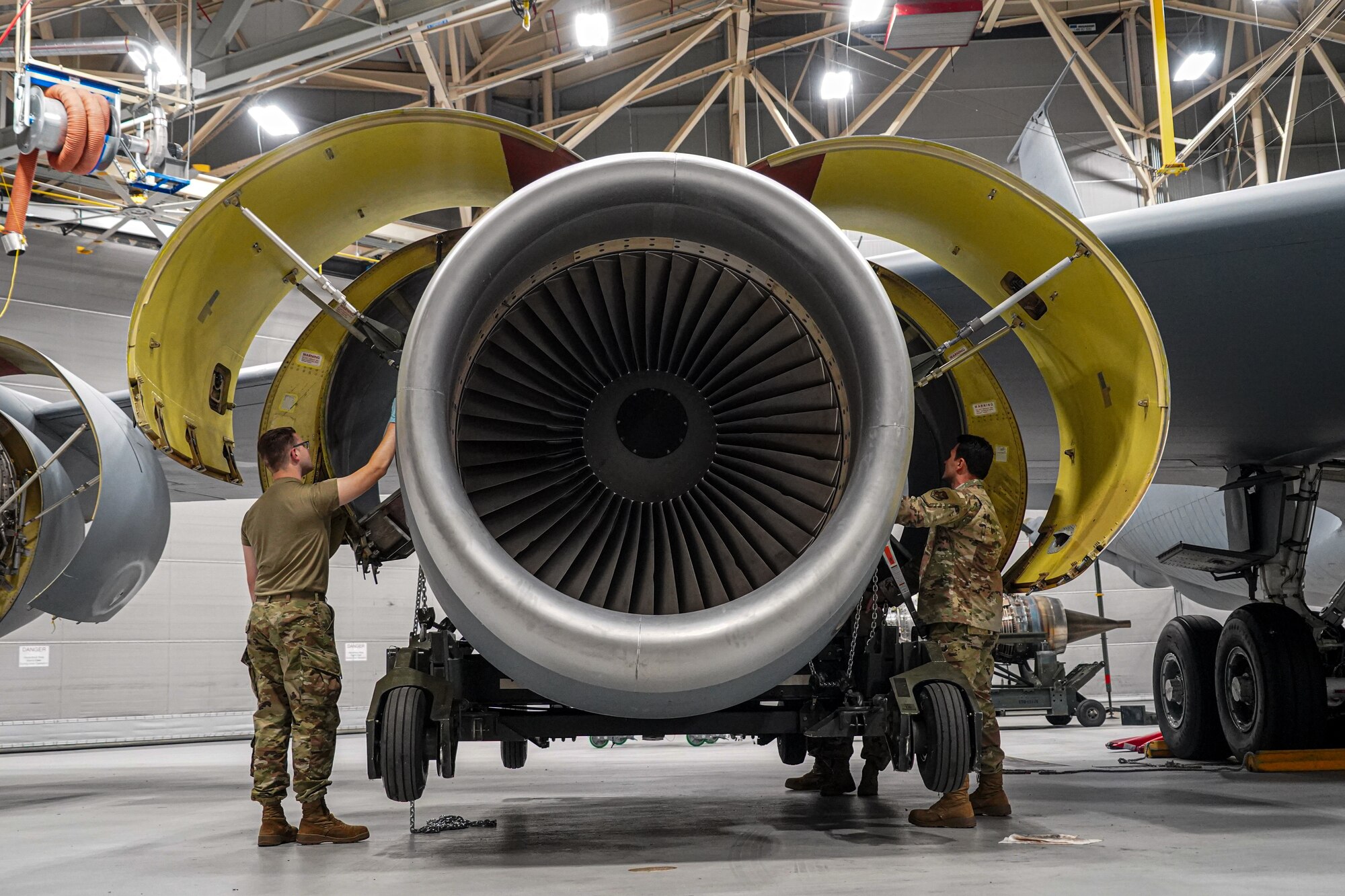 Staff Sgt. Casey Boots (left) and Tech. Sgt. Thomas Carozzolo (right), aerospace propulsion specialist assigned to the 914th Aircraft Maintenance Squadron at Niagara Falls Air Reserve Station, New York, monitored weight gauges while installing a KC-135 Stratotanker engine on Oct. 18, 2022. They must carefully monitor weight distribution to ensure the engine is even before setting it in place. (U.S. Air Force photo by 1st Lt. Lucas Morrow)