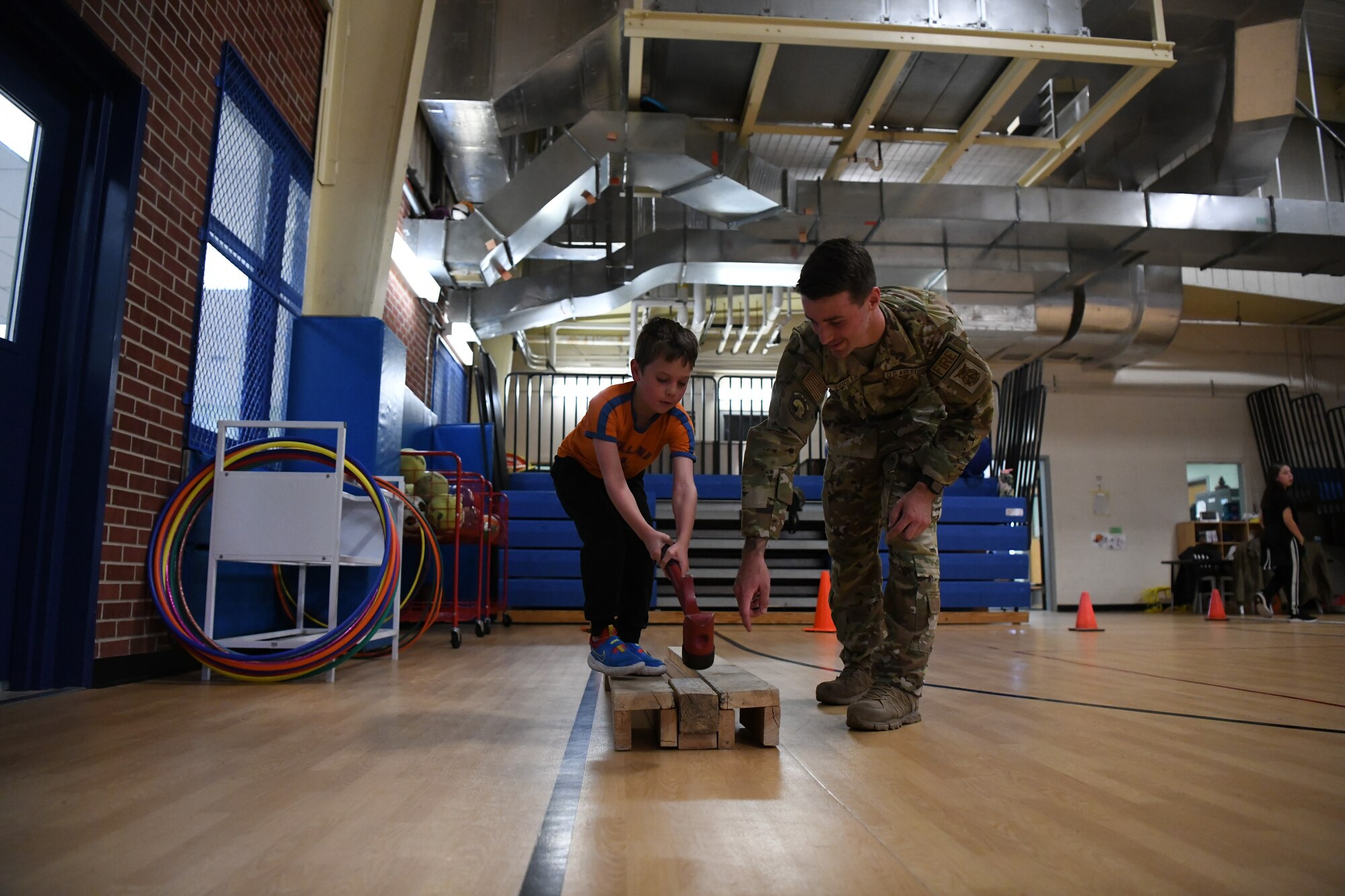 Airman Zachary Viddler, 319th Civil Engineer Squadron firefighter instructs a child how to operate the keiser force machine Oct. 14, 2022, during the junior fire fighter challenge at the youth center on Grand Forks Air Force Base, North Dakota. The 2022 Fire Prevention Week’s campaign was, “Fire won’t wait. Plan your escape.” Members of the fire department worked to educate the community about simple but important actions they can take to keep themselves and those around them safe from home fires. (U.S. Air Force Photo by Senior Airman Ashley Richards)