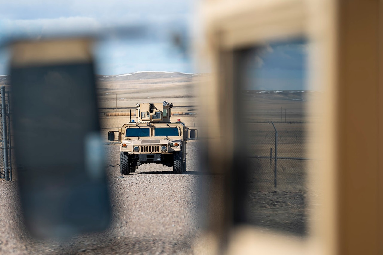 A combat vehicle moves across gravel.