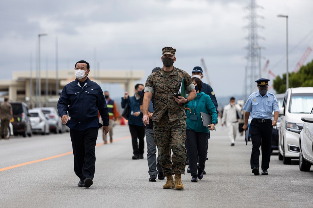 Hajime Nakama, left, the mayor of Kin, Okinawa, and U.S. Marine Corps Col. Richard M. Martin, center, the commanding officer of III MEF Information Group, observe local Japanese residents participate in a tsunami evacuation drill during Exercise Constant Vigilance 2022 on Camp Hansen, Okinawa, Japan, Oct. 18, 2022. The annual drill was held to convey the readiness and capabilities of various installations and first responders in the event of an emergency. CV22 is a Force Protection Condition and crisis response evaluation to validate regional installations, camps, and tenant antiterrorism plans and policies. (U.S. Marine Corps photo by Lance Cpl. Thomas Sheng)