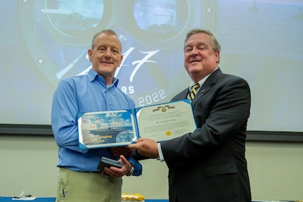 Mr. Michael Durkin, Director, Navy Warfare Development Center (NWDC), presents an award certificate for Mr. Joseph Pearl, a Military Analyst at NWDC during the U.S. Navy's 247th birthday celebration onboard NWDC October 13, 2022. Mr. Pearl received a Navy Civilian Service Achievement.