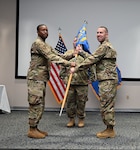 Col. Silas Darden, 960th Cyberspace Wing vice commander, presents the leadership guidon to Col. Joshua Garrison, 860th Cyberspace Operations Group commander, during the 860th COG change of command ceremony at Joint Base San Antonio-Lackland, Texas, Oct. 15, 2022. (U.S. Air Force photo by Staff Sgt. Monet Villacorte)