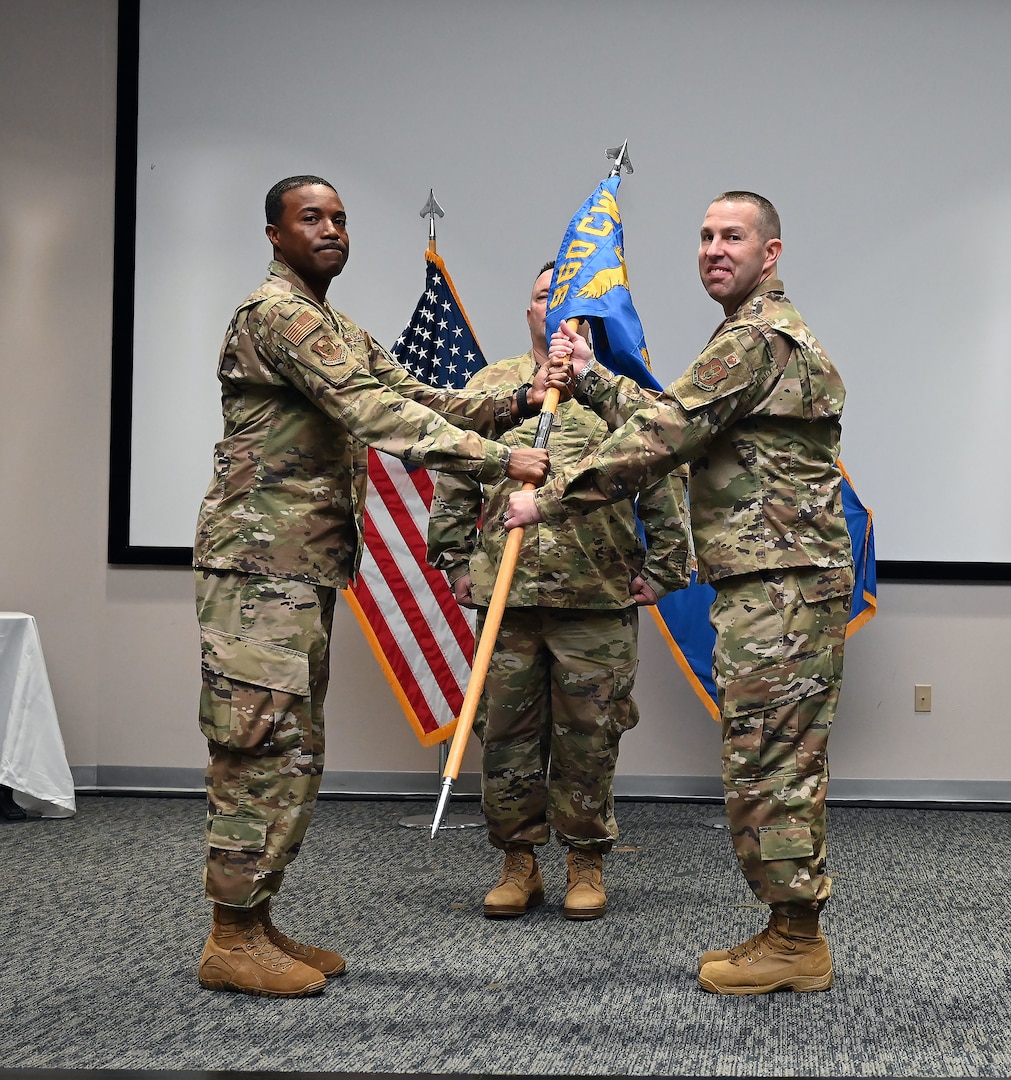 Col. Silas Darden, 960th Cyberspace Wing vice commander, presents the leadership guidon to Col. Joshua Garrison, 860th Cyberspace Operations Group commander, during the 860th COG change of command ceremony at Joint Base San Antonio-Lackland, Texas, Oct. 15, 2022. (U.S. Air Force photo by Staff Sgt. Monet Villacorte)