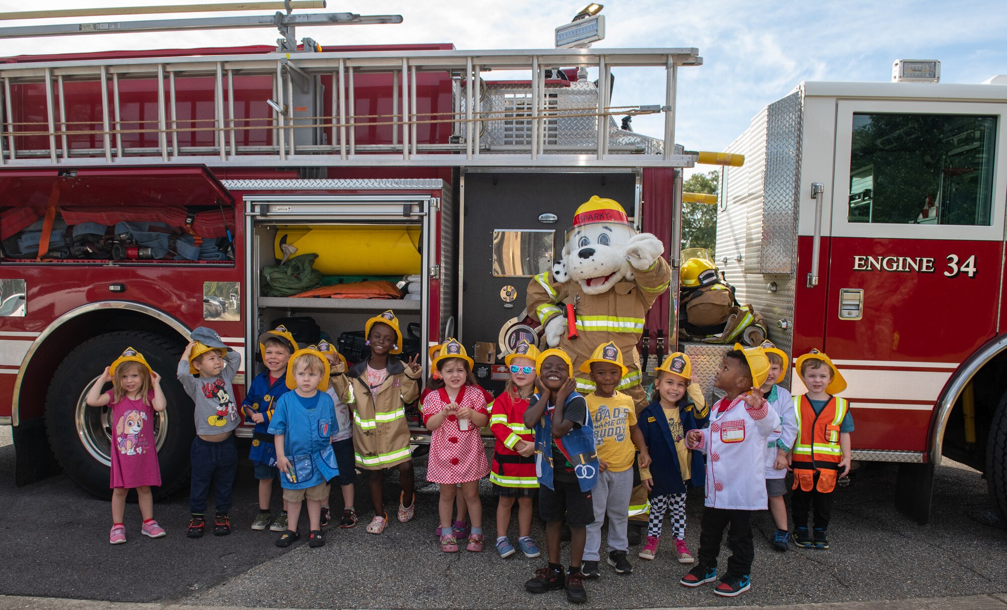 Children from the Child Development Center pose for a group photo with Sparky the fire dog, the official mascot of the National Fire Protection Association during the Fire Prevention Week tour at the CDC on Keesler Air Force Base, Mississippi, Oct. 13, 2022. Throughout the week the Keesler Fire Department conducted random fire drills, toured various facilities with Sparky the fire dog, passed out fire safety information and fire hats for children. (U.S. Air Force Photo by Andre' Askew)