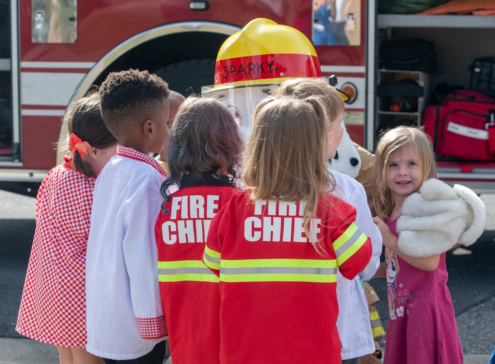 Children from the Child Development Center receives a hug from Sparky the fire dog, the official mascot of the National Fire Protection Association during the Fire Prevention Week tour at the CDC on Keesler Air Force Base, Mississippi, Oct. 13, 2022. Throughout the week the Keesler Fire Department conducted random fire drills, toured various facilities with Sparky the fire dog, passed out fire safety information and fire hats for children. (U.S. Air Force Photo by Andre' Askew)