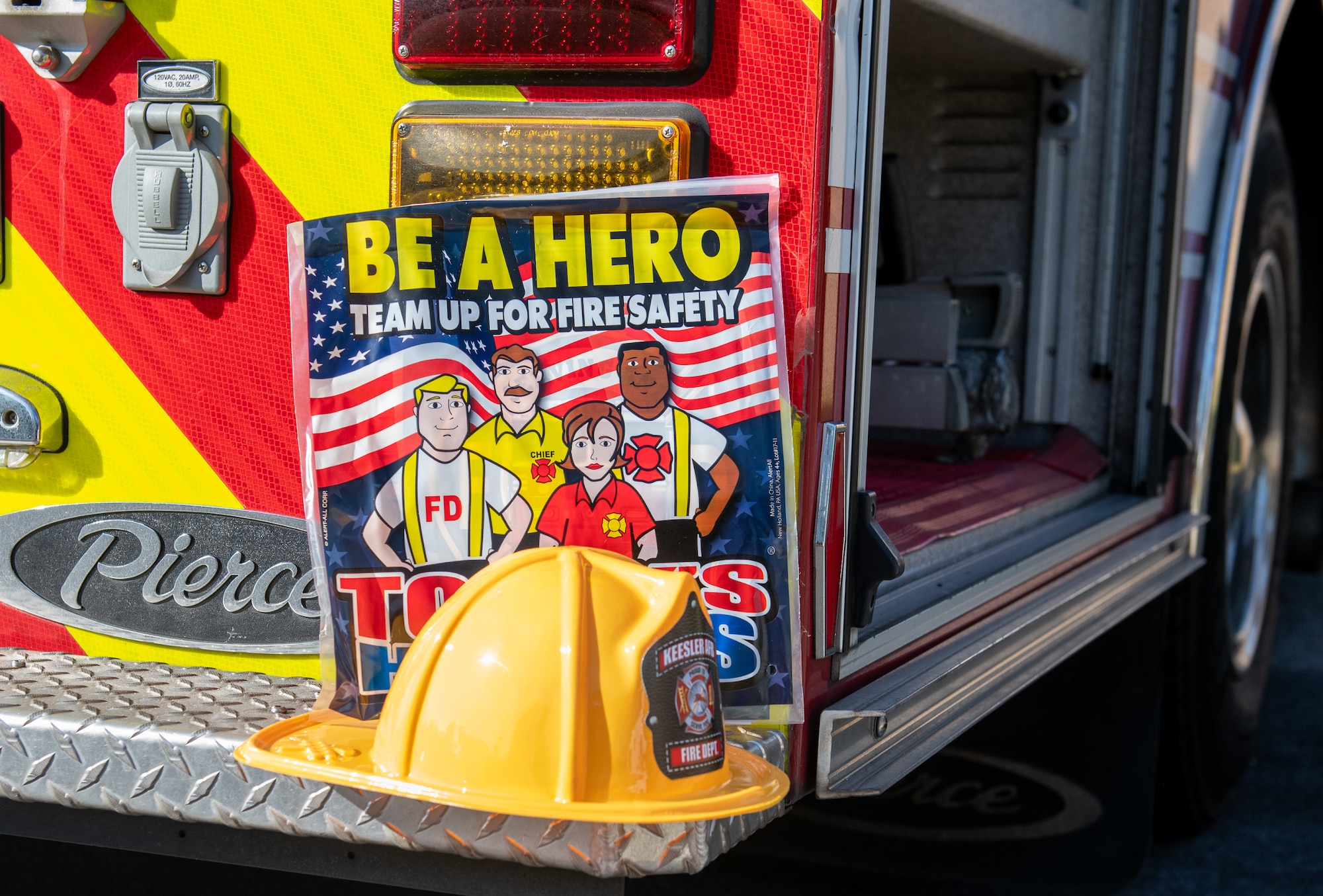 A plastic fire fighter hat and safety information is displayed on a fire truck during the Fire Prevention Week tour at the Child Development Center on Keesler Air Force Base, Mississippi, Oct. 13, 2022. Throughout the week the Keesler Fire Department conducted random fire drills, toured various facilities with Sparky the fire dog, passed out fire safety information and fire hats for children. (U.S. Air Force Photo by Andre' Askew)