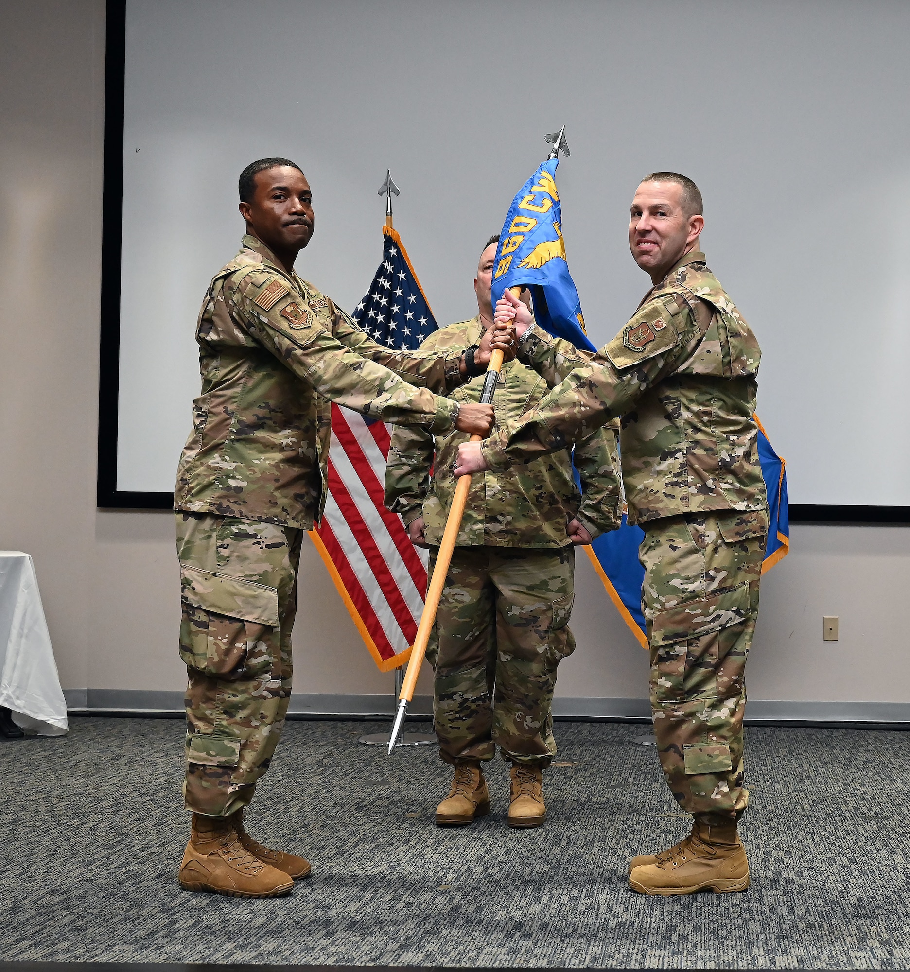 Col. Silas Darden, 960th Cyberspace Wing vice commander, presents the leadership guidon to Col. Joshua Garrison, 860th Cyberspace Operations Group commander, during the 860th COG change of command ceremony at Joint Base San Antonio-Lackland, Texas, Oct. 15, 2022. (U.S. Air Force photo by Staff Sgt. Monet Villacorte)