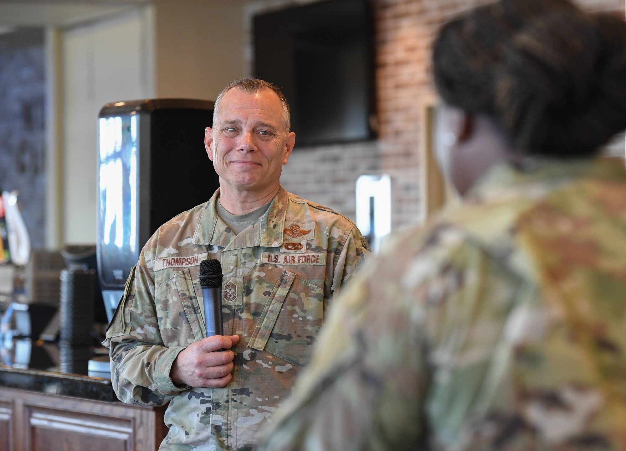 U.S. Air Force Chief Master Sgt. Erik Thompson, command chief of Air Education and Training Command, receives a question from Staff Sgt. DeJanae Acey, 902nd Civil Engineering Squadron command support staff noncommissioned officer in charge, during an AETC all-call amid the inaugural Torch and Dagger professional development seminar at Keesler Air Force Base, Mississippi, October 15, 2022.