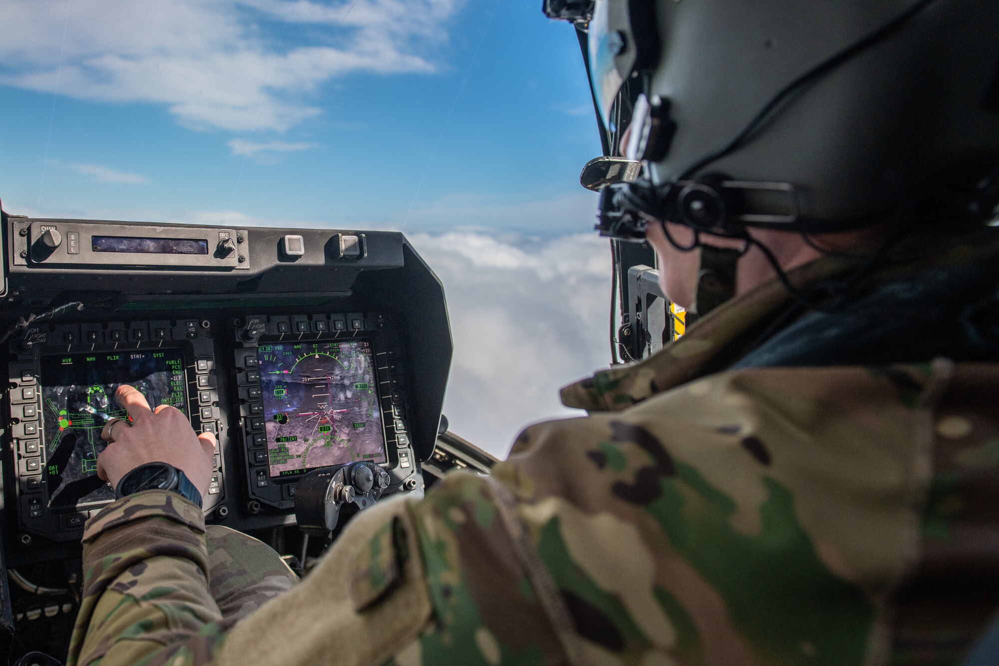 A CV-22 Osprey pilot adjusts monitor settings in flight