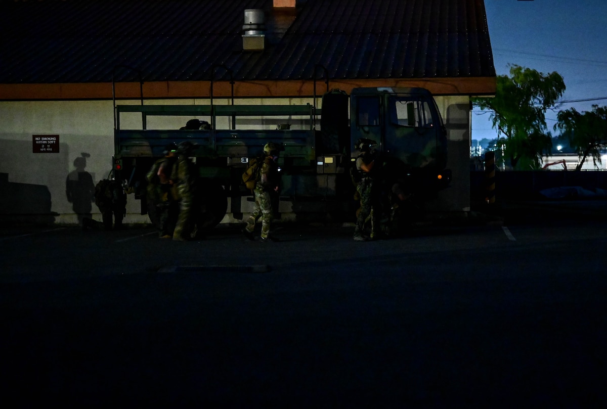 Operators participating in a combined U.S. and Republic of Korea (ROK) special operations forces training, seek cover behind a truck
