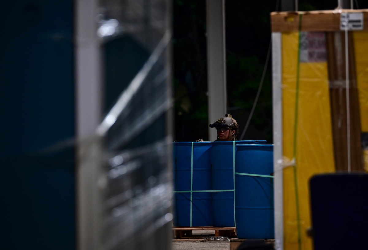 An operator participating in a combined U.S. and Republic of Korea (ROK) special operations forces training, peeks out behind some barrels