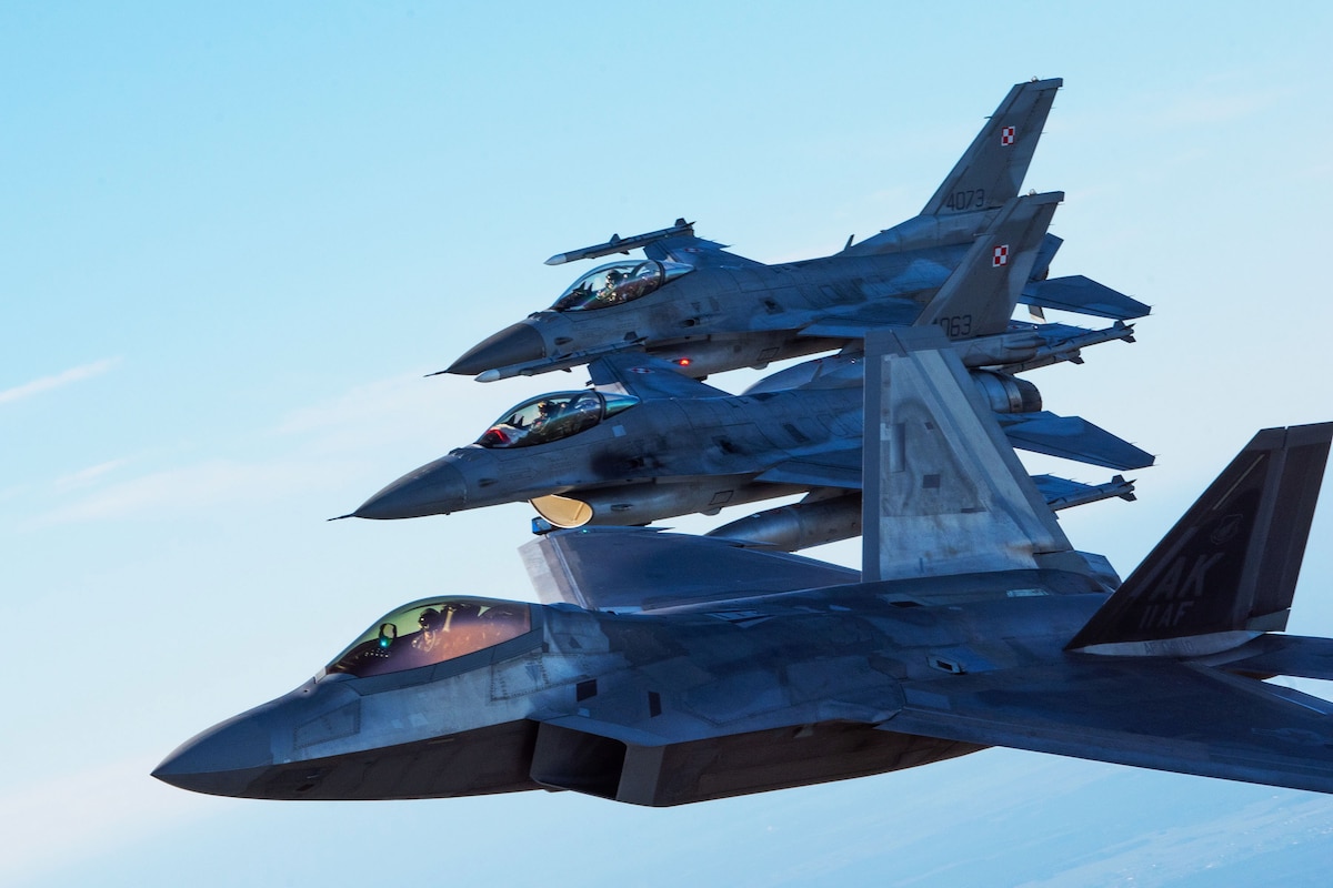 Three jets fly side-by-side in a tight formation.