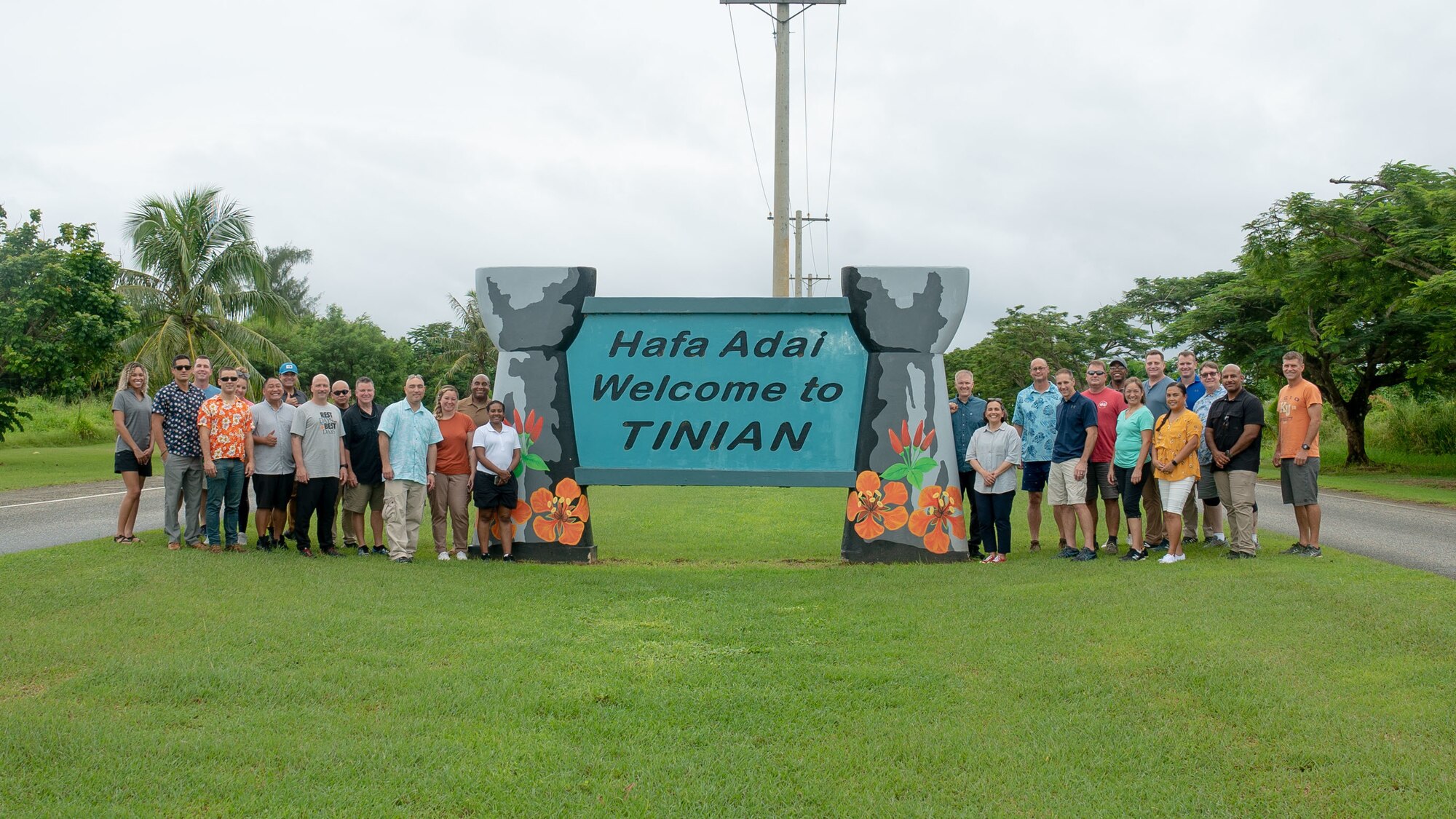 36th Wing leadership pose in front of a welcome sign during an off-site at Tinian on Oct. 11, 2022.  During the off-site, leadership spent time viewing historical sites from World War II and met with Tinian’s mayor and local government to solidify relationships and improve their ability to mutually support one another. (U.S. Air Force photo by 1st Lt. Jade Watkins)