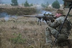 Staff Sgt. Chris Smith fires from a hasty kneeling position during the enhanced Forward Presence Battle Group Latvia International Sniper Competition at Camp Adazi, Latvia, Nov. 16, 2021. The LISC was created to bring sniper teams from across NATO together to share knowledge and engage in challenging, friendly competition.