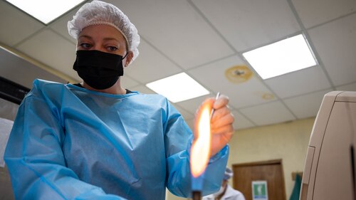 Master Sgt. Amanda Evans, 934th Aeromedical Staging Squadron laboratory technician, sterilizes a loop for bacteriology at the Hospital Militar Central in San Salvador, El Salvador, during Resolute Sentinel 2022.