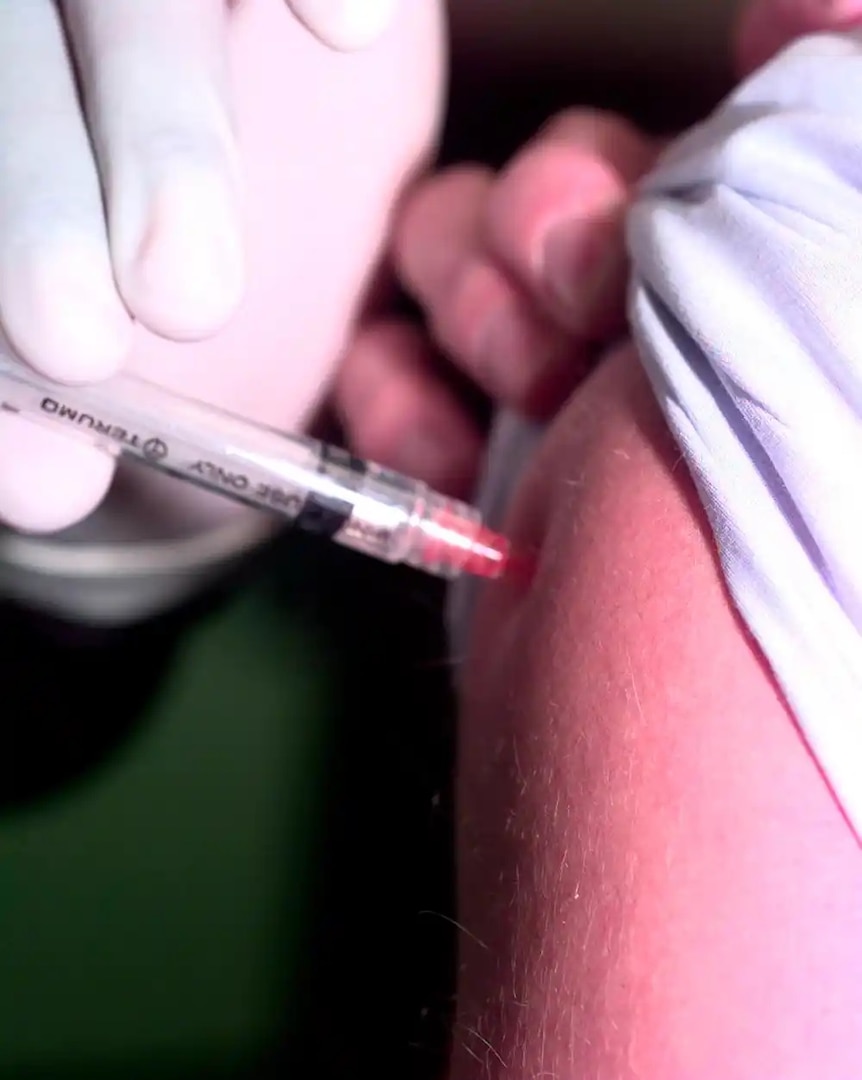 A Health Services Technician administers the Influenza vaccine. USCG photo by Petty Officer 3rd Class Bridget Hieronymus.