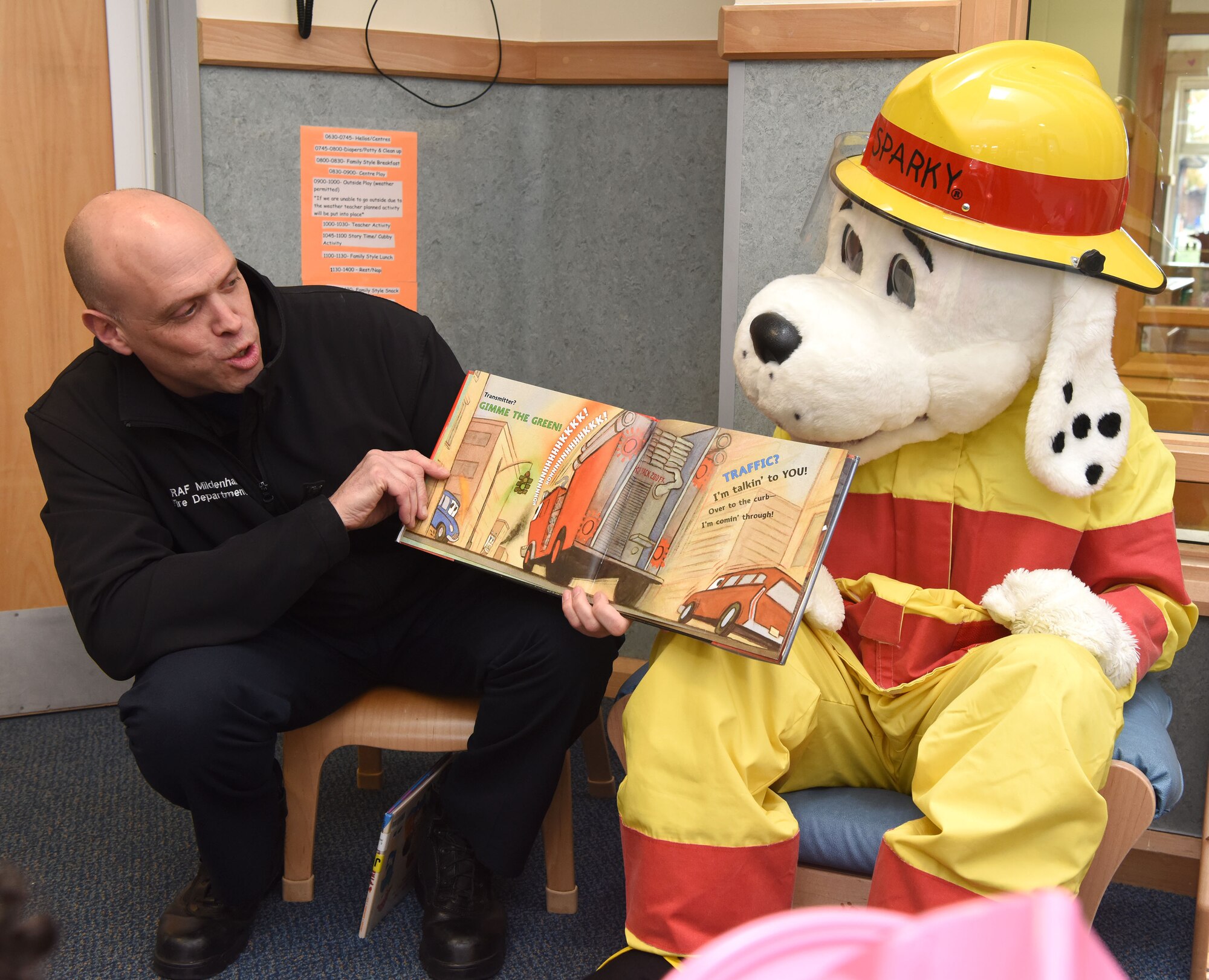 Nathan Taylor, 100th Civil Engineer Squadron fire prevention lead fire inspector, reads a story to pre-school children Royal Air Force Mildenhall, England, Oct. 12, 2022. Sparky the Fire Dog and his firefighter friends visited the child development center as part of Fire Prevention Week events. This year’s FPW theme is “Fire won’t wait: Plan your escape.” Other activities included information booths, open house at the fire department, bowling and a fire muster. (U.S. Air Force photo by Karen Abeyasekere)