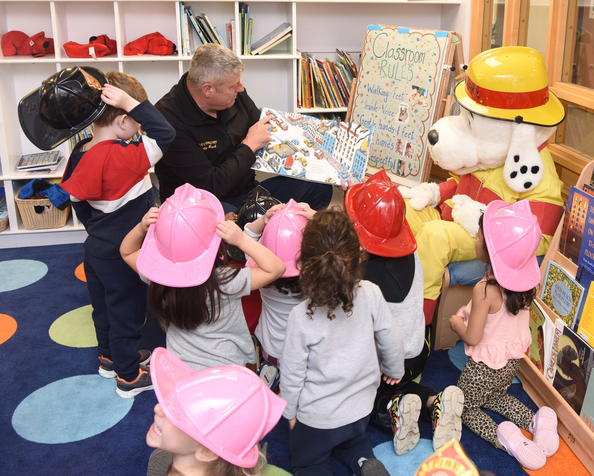 Martin Lash, 100th Civil Engineer Squadron deputy fire chief, reads a story to pre-schoolers at the child development center as part of Fire Prevention Week at Royal Air Force Mildenhall, England, Oct. 12, 2022. This year’s FPW theme is “Fire won’t wait: Plan your escape.” Other activities included information booths, open house at the fire department, bowling and a fire muster. (U.S. Air Force photo by Karen Abeyasekere)