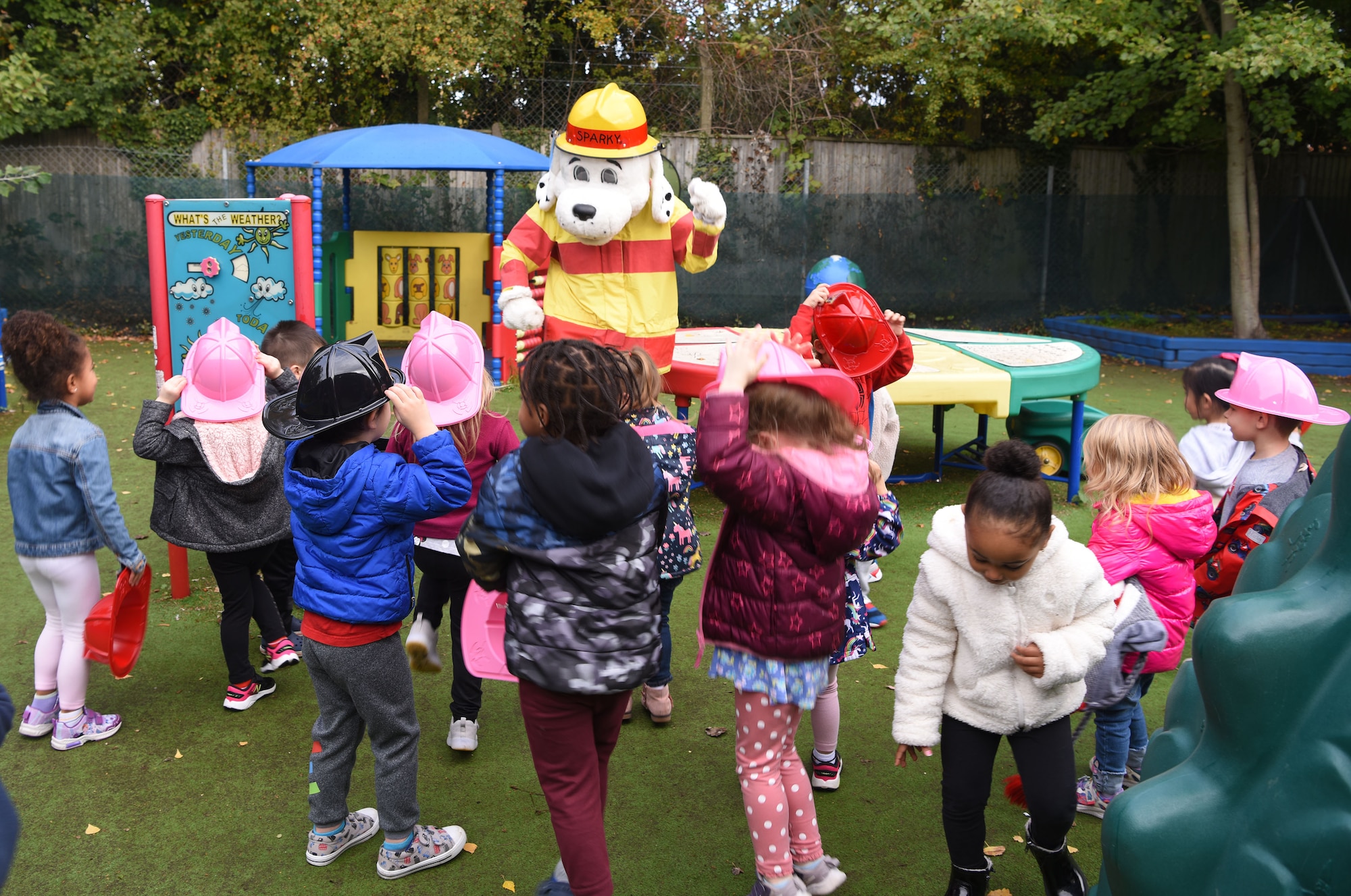 Sparky the Fire Dog dances with pre-schoolers at the child development center during a visit as part of Fire Prevention Week at Royal Air Force Mildenhall, England, Oct. 12, 2022. This year’s FPW theme is “Fire won’t wait: Plan your escape.” Other activities included information booths, open house at the fire department, bowling and a fire muster. (U.S. Air Force photo by Karen Abeyasekere)