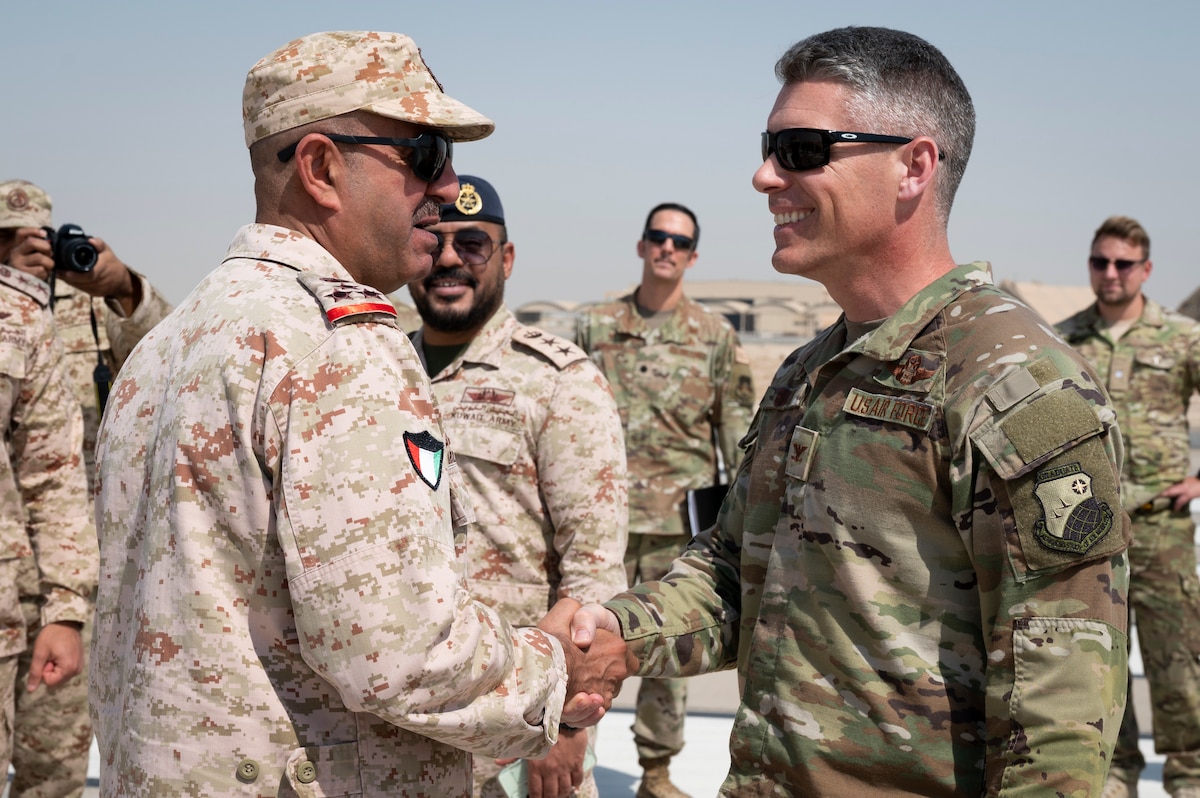 Kuwait Air Force Brig. Gen. Murbarke Al-Qahtani, Ali Al Salem Air Base commander, and U.S. Air Force Col. George Buch Jr., 386th Air Expeditionary Wing commander, greet each other before a ribbon cutting ceremony for the reopening of the South runway and taxiway at Ali Al Salem Air Base, Kuwait, October 13, 2022. With the runway construction completed, the runway will enable future mission success for years to come and is symbolic of the fruits of joint and coalition teamwork. (U.S. Air Force photo by Staff Sgt. Dalton Williams)