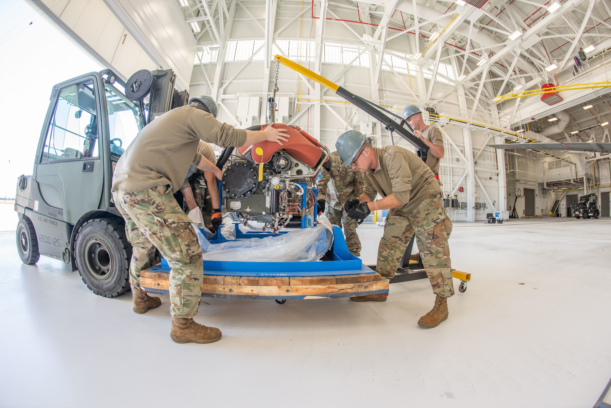 Engine mechanics with the 157th Maintenance Group suspend an auxiliary power unit inside a hangar Sept. 27, 2022 at Pease Air National Guard Base, New Hampshire.