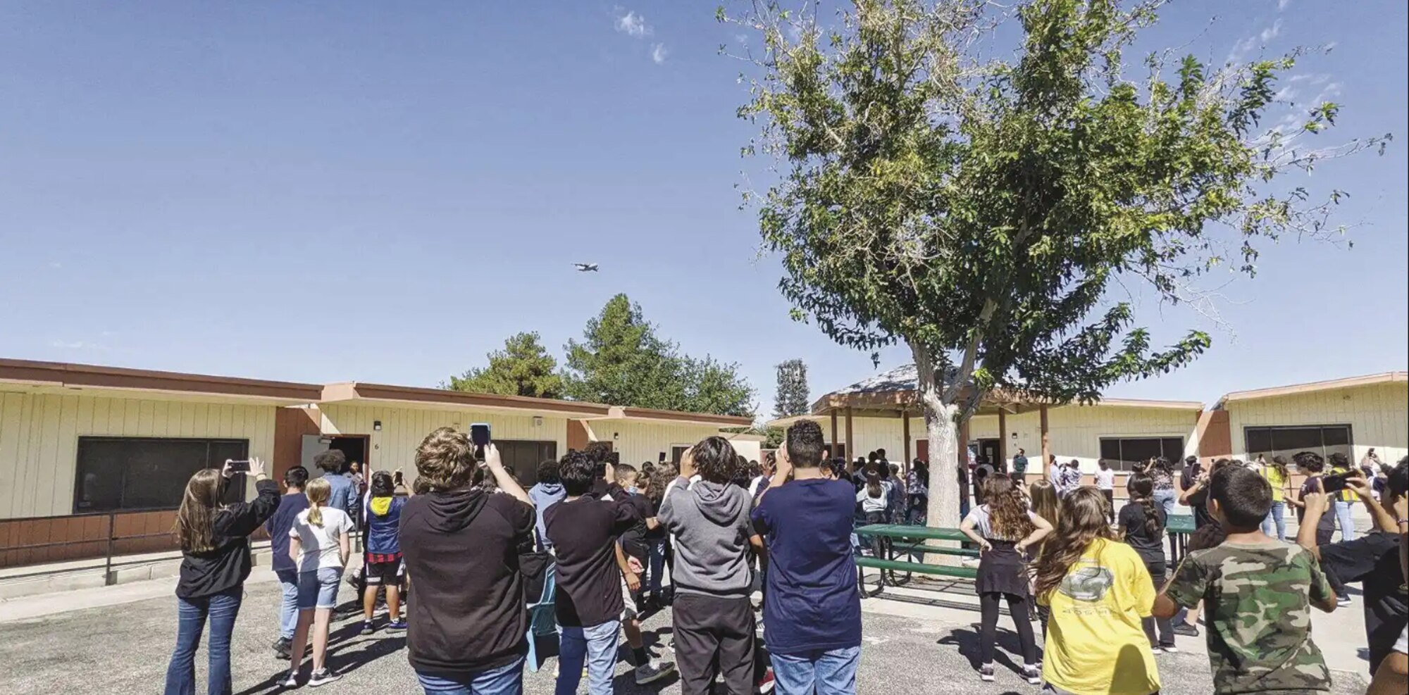 Fulton and Alsbury Academy of Arts and Engineering students take pictures as a C-17 flies above their campus Oct 12., as part of a preview for the Aerospace Valley Air Show’s STEM Expo. The Aerospace Valley Open House, Air Show & STEM Expo took place Friday through Sunday at Edwards Air Force Base. (Photo by Julie Drake/Valley Press)