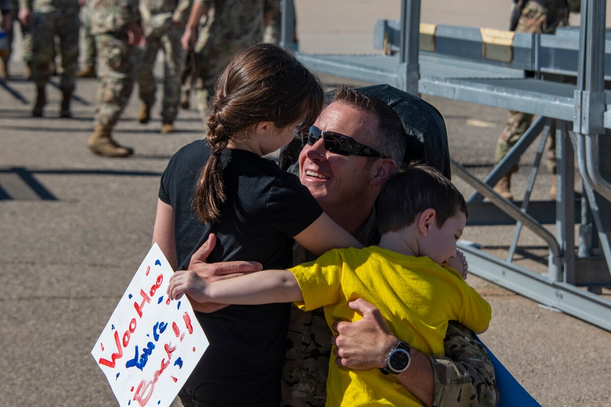 A photo of a family member greeting a loved one that came home from deployment