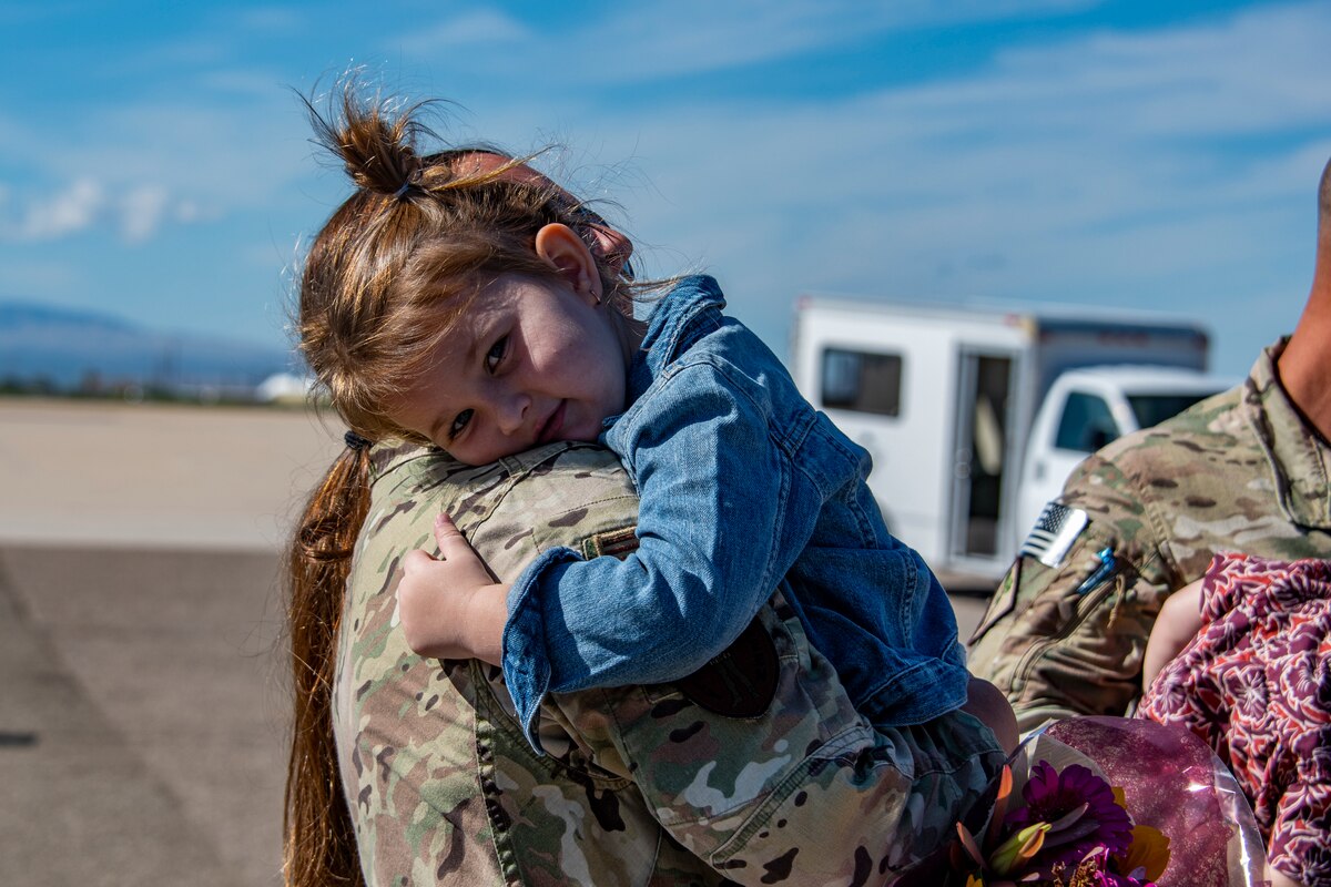 A photo of a family member greeting a loved one that came home from deployment