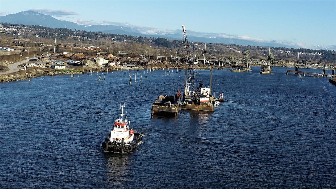 A tugboat is returning the barge and leaving the area along the Snohomish River.