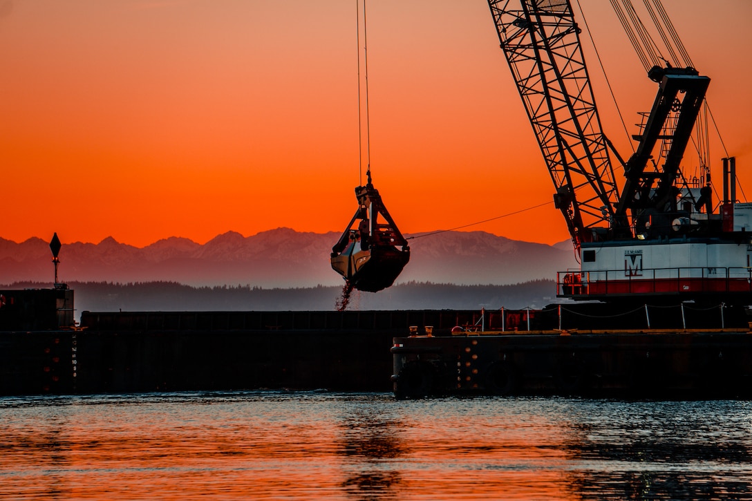 A commercial vessel is lowering a dredging claw to remove sediment in Everett Harbor along the Snohomish River.