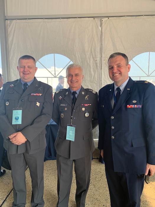 Three men pose for a photo at the Air and Space Expo Show at Joint Base Andrews, Maryland.