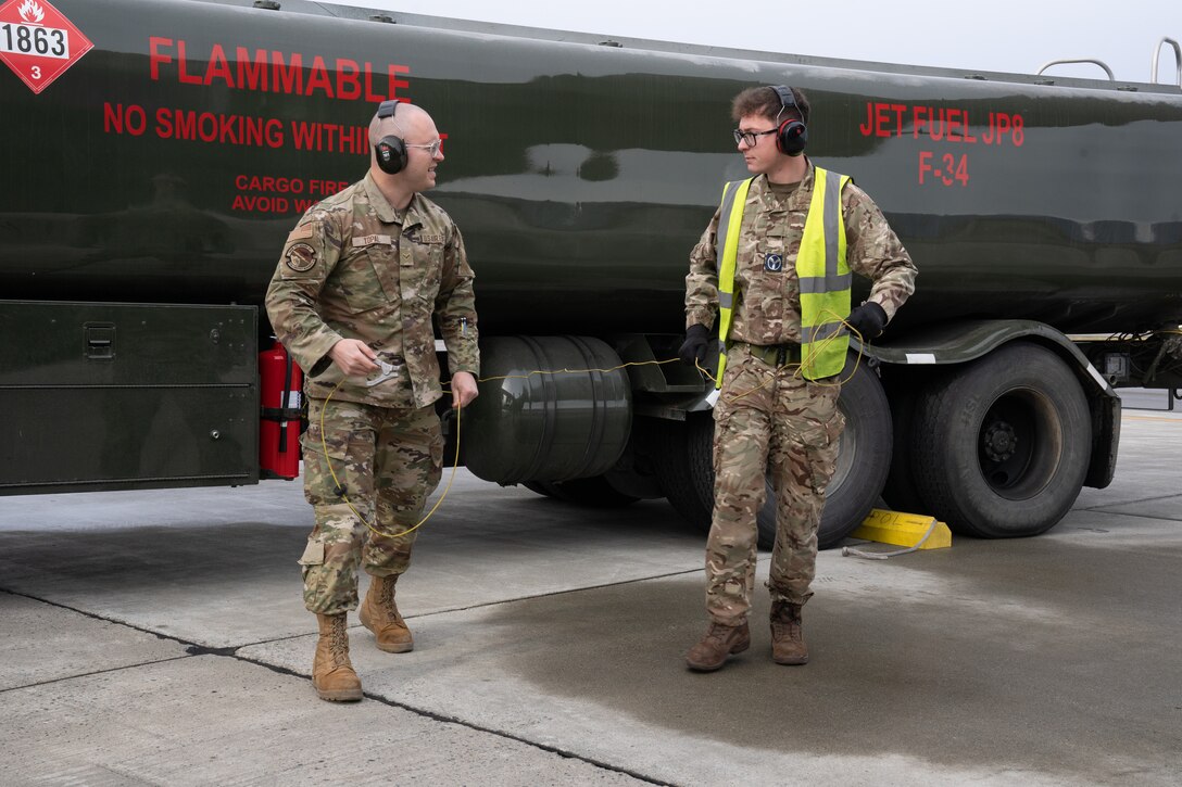 U.S. Air Force Airman 1st Class Mikhail Topal and British Royal Air Force Air Specialist (Class 1) Technician Alex Parker prepare to fuel a plane