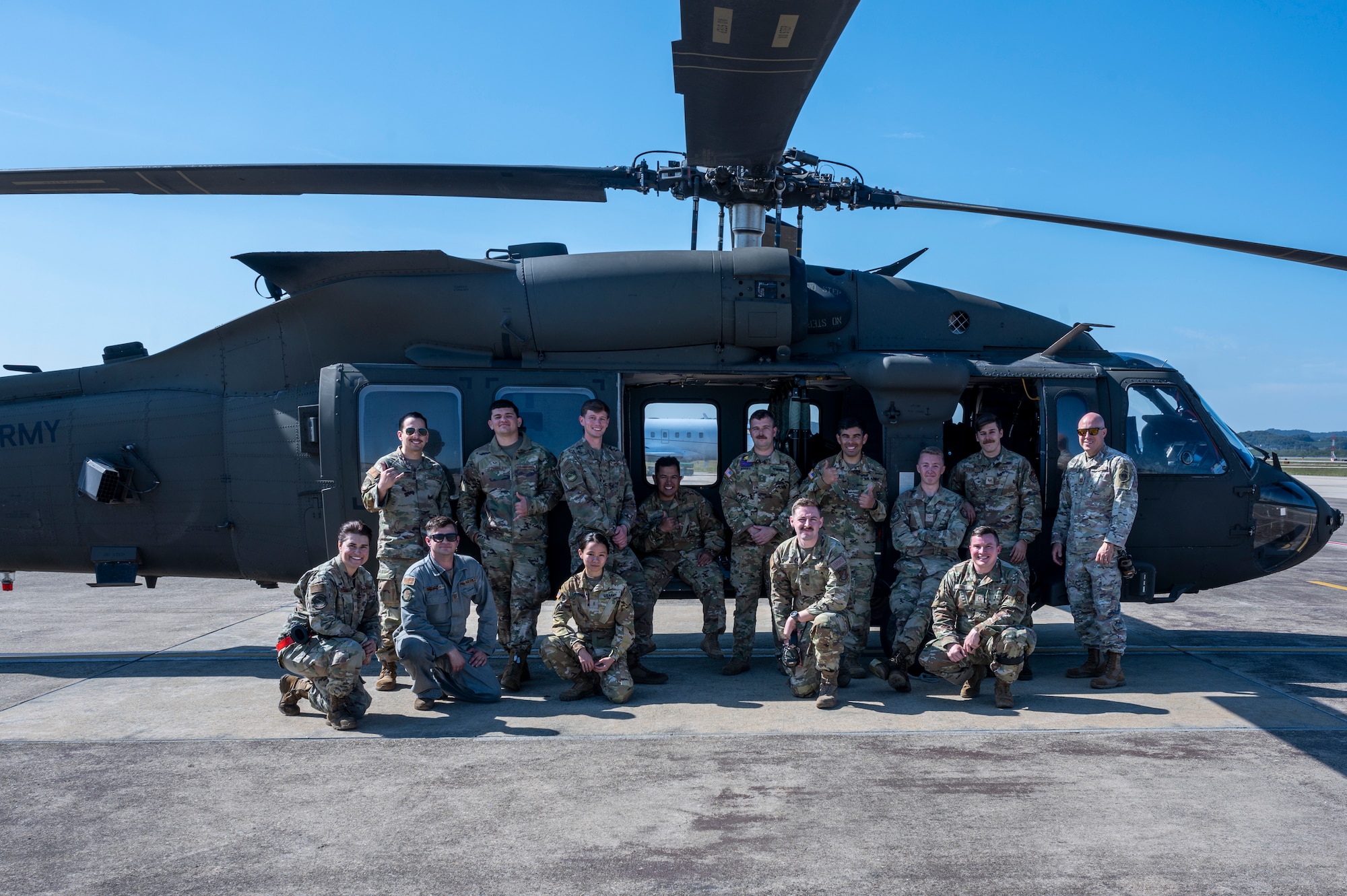 U.S. Air Force 51st Maintenance Group Airmen pose for a photo with U.S. Army 2-2 Assault Helicopter Battalion Soldiers in front of a Black Hawk helicopter after an integrated sling load training at Osan Air Base, Republic of Korea, Oct. 13, 2022.