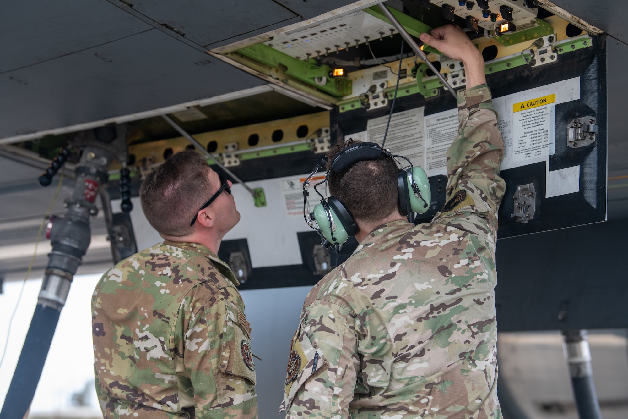 Senior Airman Stephen Ingram, 22nd Aircraft Maintenance Squadron electrical and environmental apprentice, and Master Sgt. Trevor Kuhns, 22nd Operations Support Squadron Agile Combat Employment program lead, check the fuel levels during a hot pit refueling mission Oct. 13, 2022, at Kadena Air Base, Japan.