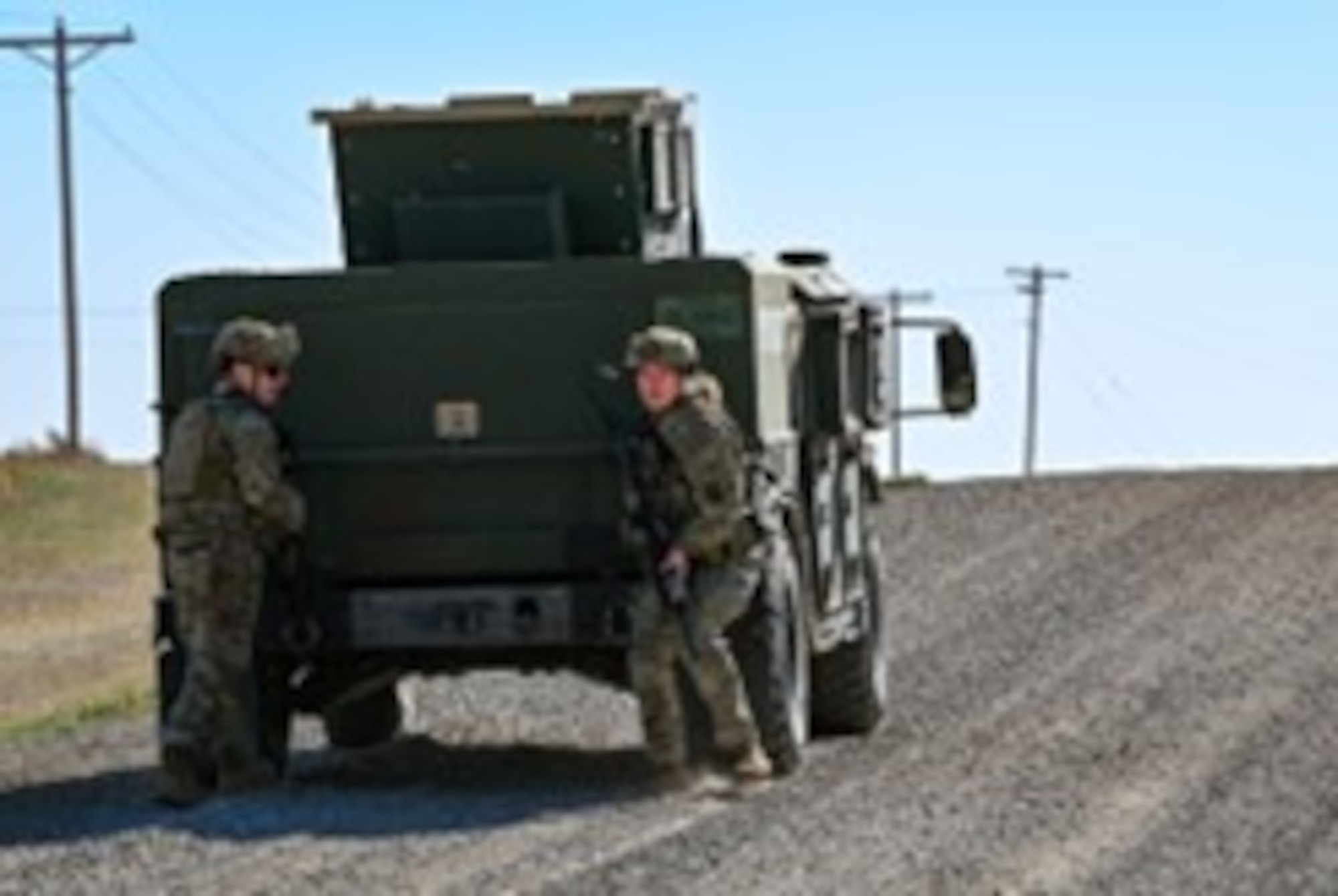 Members 91st Security Forces Group take cover behind a High Mobility Multipurpose Wheeled Vehicles (HMMWV) during Exercise Bully Vigilance at Minot Air Force, North Dakota, Oct. 13, 2022. BV is an semi-annual command and control exercise designed to train U.S. Strategic Command forces and assess joint operational readiness. (U.S. Air Force photo by Senior Airman Zachary Wright)