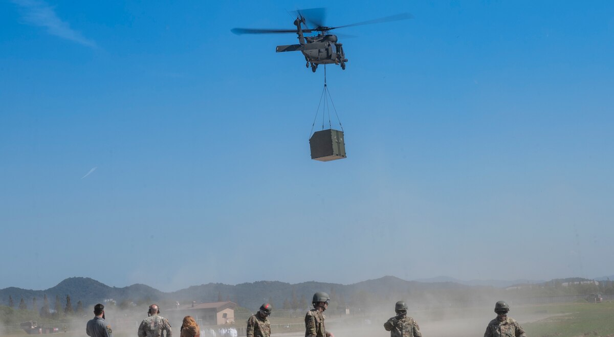A U.S. Army Black Hawk helicopter carries an Internal Slingable Unit during an integrated sling load training at Osan Air Base, Republic of Korea, Oct. 13, 2022.