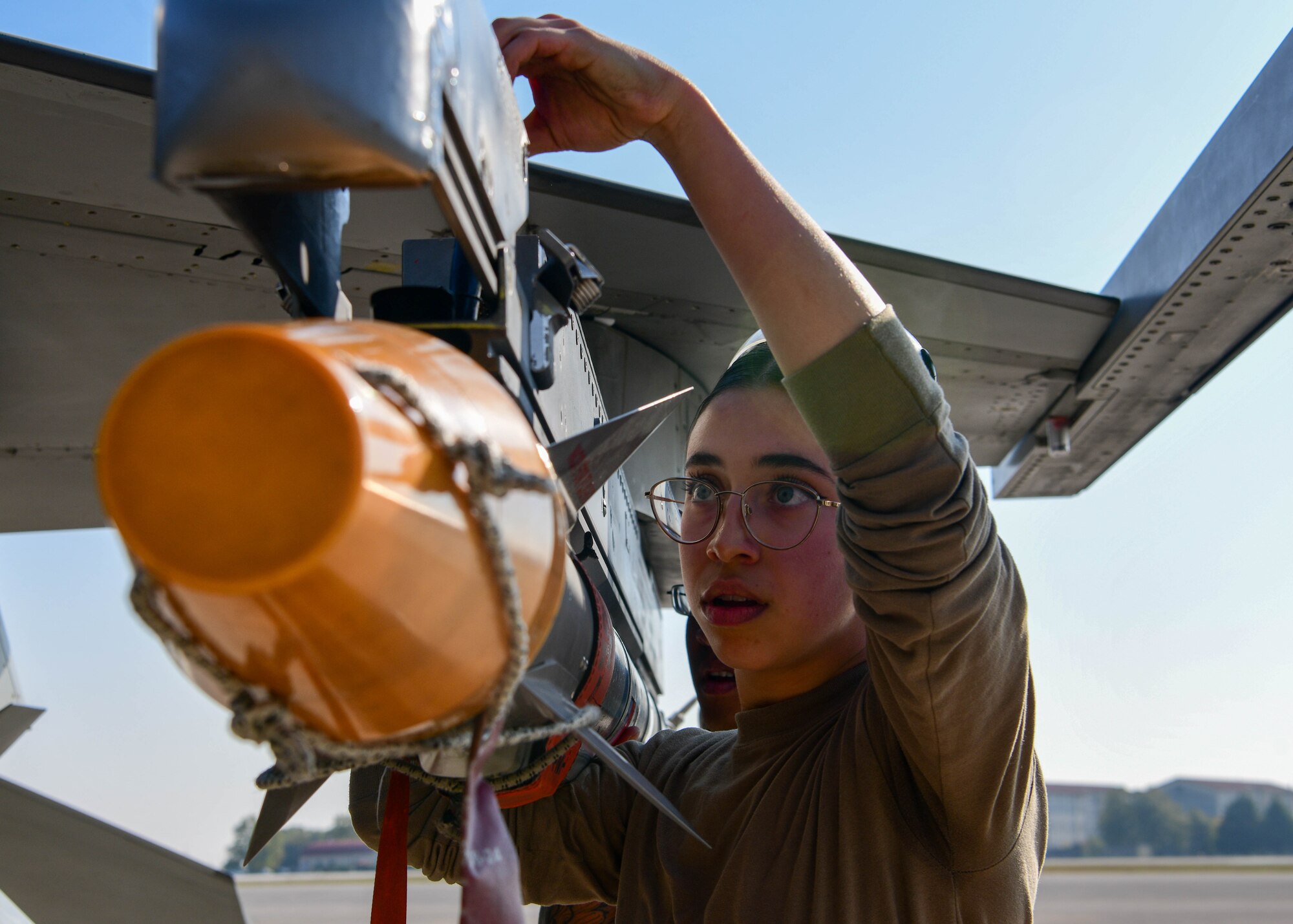 Airman 1st Class Addison Jones, 510th Fighter Generation Squadron weapons load crew member, secures an AIM-9L/M Sidewinder onto an F-16 Fighting Falcon during the 3rd quarter Rapid Aircraft Generation and Employment (RAGE) event at Aviano Air Base, Italy, Oct.14, 2022. The weapons load crews competed head-to-head and were tasked to load an F-16 with an inert guided bomb unit-31v3 Joint Direct Attack Munition (JDAM), a MK-84 Low Drag and one AIM-9L/M Sidewinder in the shortest possible time. (U.S. Air Force photo by Senior Airman Brooke Moeder)