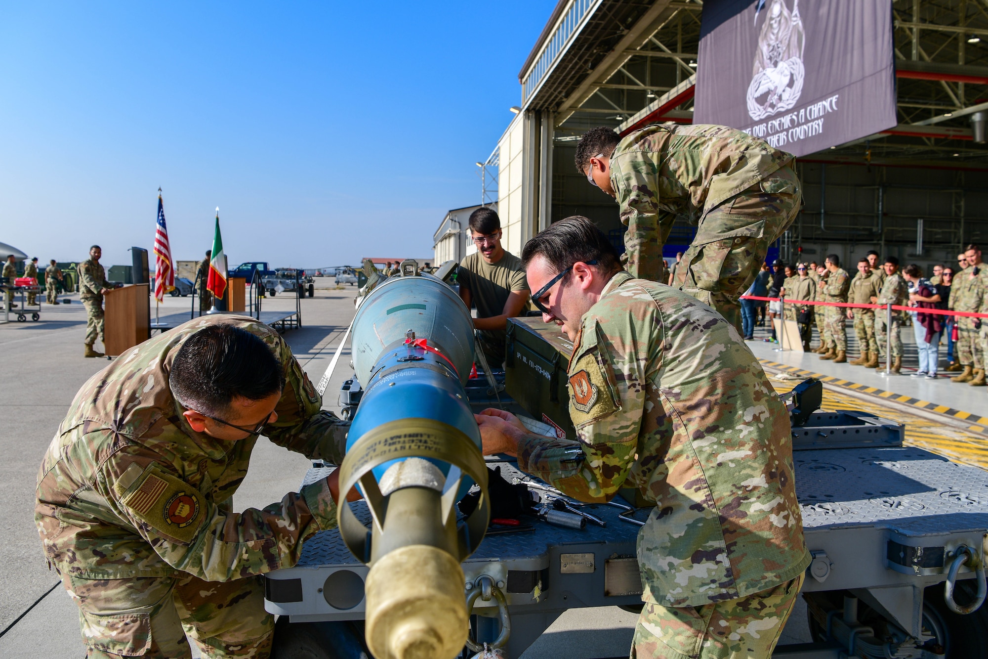 U.S. Air Force Airmen assigned to the 31st Munitions Squadron build an inert munition during a Bomb Build competition at Aviano Air Base, Italy, Oct. 14, 2022. The Bomb Build competition was held during the 3rd quarter Rapid Aircraft Generation and Employment (RAGE) event, alongside a weapons loading competition. (U.S. Air Force photo by Senior Airman Brooke Moeder)