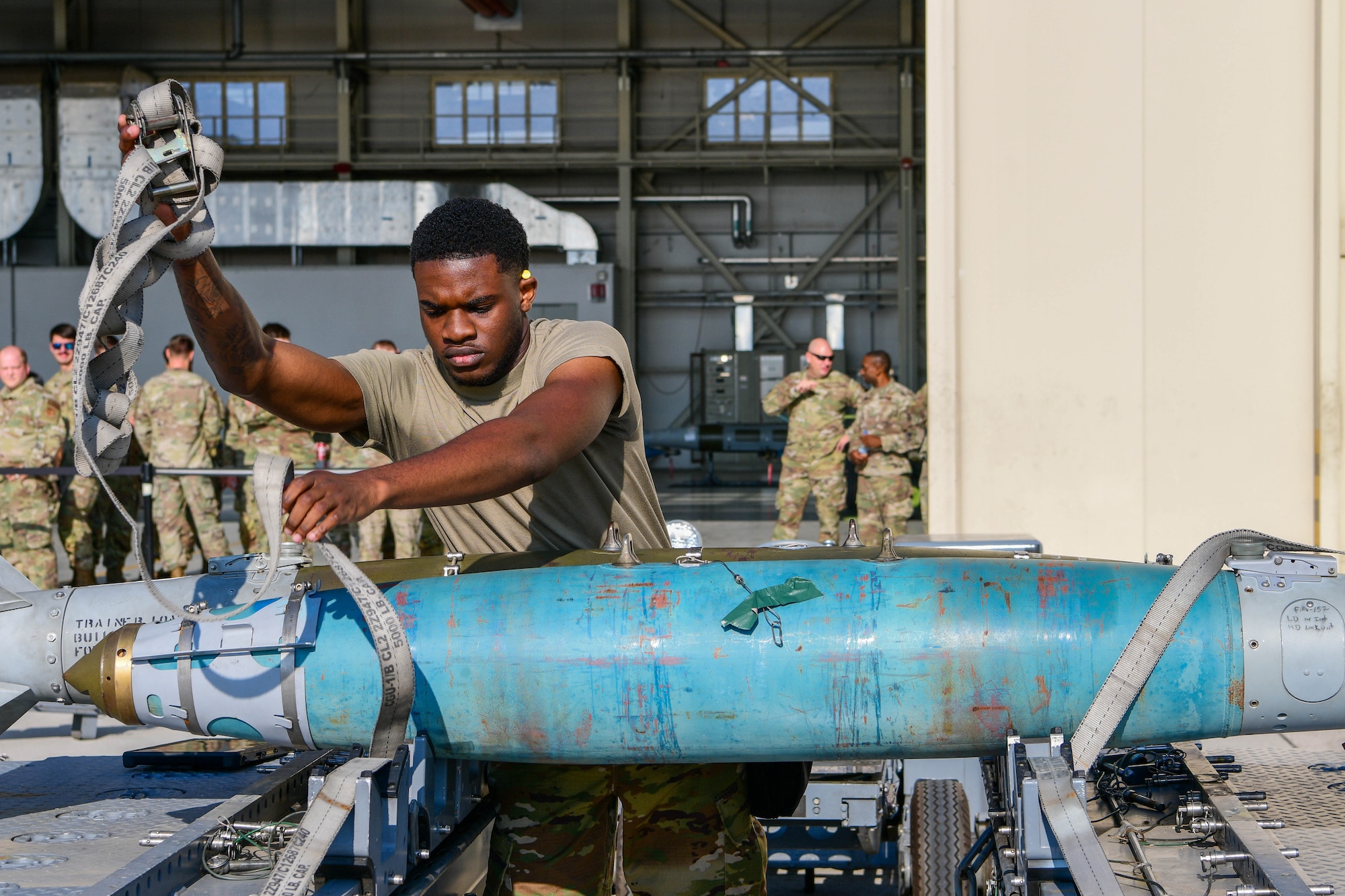 U.S. Air Force Airman Jadon Nurse, 510th Fighter Generation Squadron weapons load crew member, prepares an inert munition to be loaded onto an F-16 Fighting Falcon during the 3rd quarter Rapid Aircraft Generation and Employment (RAGE) event at Aviano Air Base, Italy, Oct. 14, 2022. The weapons load crews competed head-to-head to see which team could perform the most effective and reliable munitions load in the shortest amount of time. (U.S. Air Force photo by Senior Airman Brooke Moeder)