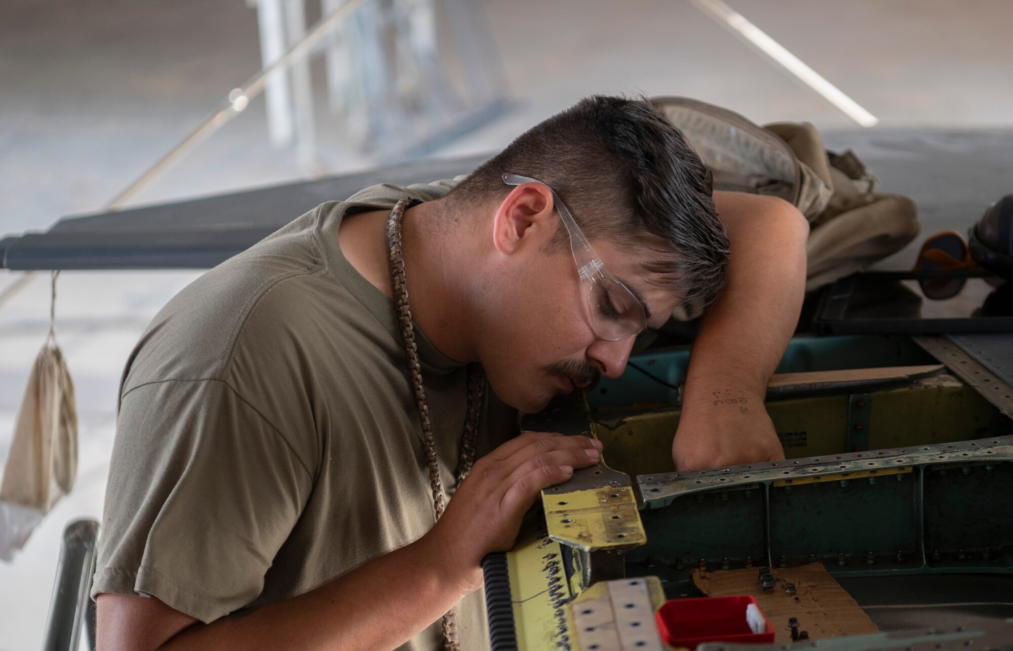 332d Expeditionary Maintenance Squadron Aircraft Structural Maintenance specialists replace three hinge segments on the Aileron flight control surfaces attached to the wing of an F-15E Strike Eagle at an undisclosed location in Southwest Asia, September 27, 2022. EMXS Airmen ensure the structural quality of Air Force aircraft, utilizing various methods to include installing replacement parts and building a replacement from scratch in order to restore the structural integrity of the aircraft, ensuring the safety of the pilots who fly them. (U.S. Air Force photo by Tech. Sgt. Jeffery Foster)