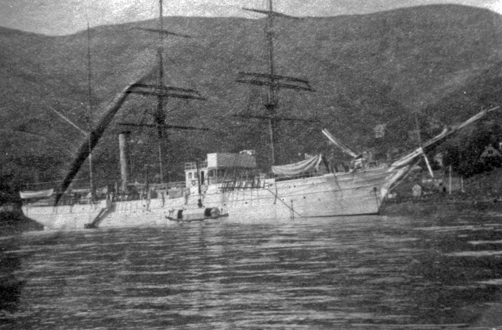 Rare photograph of Thetis at anchor in calm Hawaiian waters.
