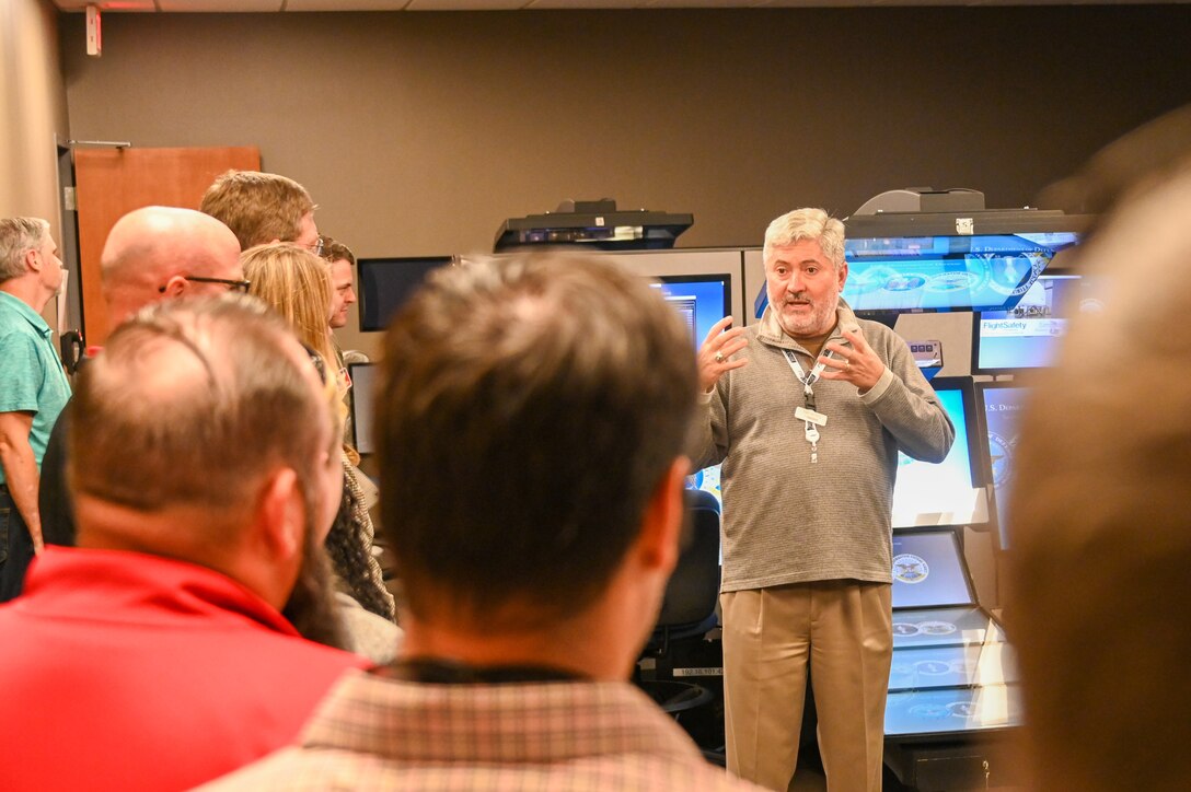 Stephen Grice, 97th Training Squadron contracting officer representative, talks to community members about KC-46 Pegasus simulators at Altus Air Force Base, Oklahoma, Oct. 18, 2022. Community members toured a KC-46 as well as the pilot and boom operator simulators. (U.S. Air Force photo by Senior Airman Kayla Christenson)