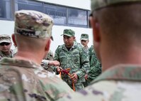Mexican army Subteniente (Lieutenant) Eduardo Bobadilla, assigned to the 19th Motorized Cavalry, demonstrates how to use a self-lowering device to U.S. Soldiers assigned to the 92nd Engineer Battalion, 526th Engineer Construction Company, based out of Fort Stewart, Ga., during exercise Fuerzas Amigas 2022 on Campo Militar Reynosa, Mexico, Oct. 17, 2022.