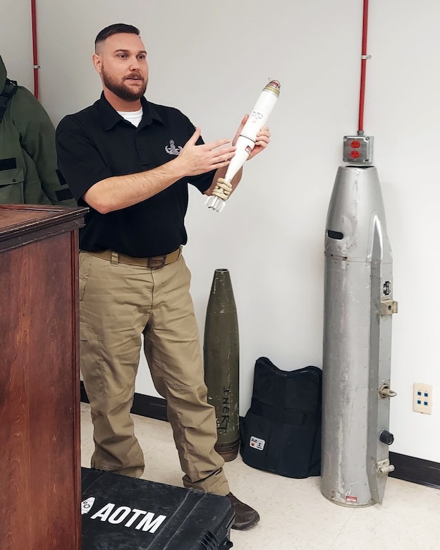 A man holds a small bomb.