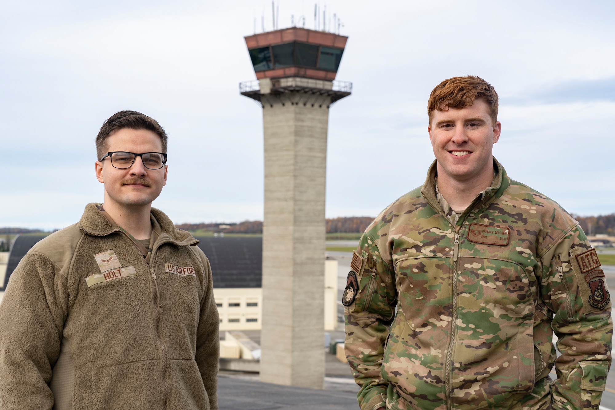 A photo of A1C Ean Holt and Staff Sgt. Brennan Gettinger posing by the ATC tower.